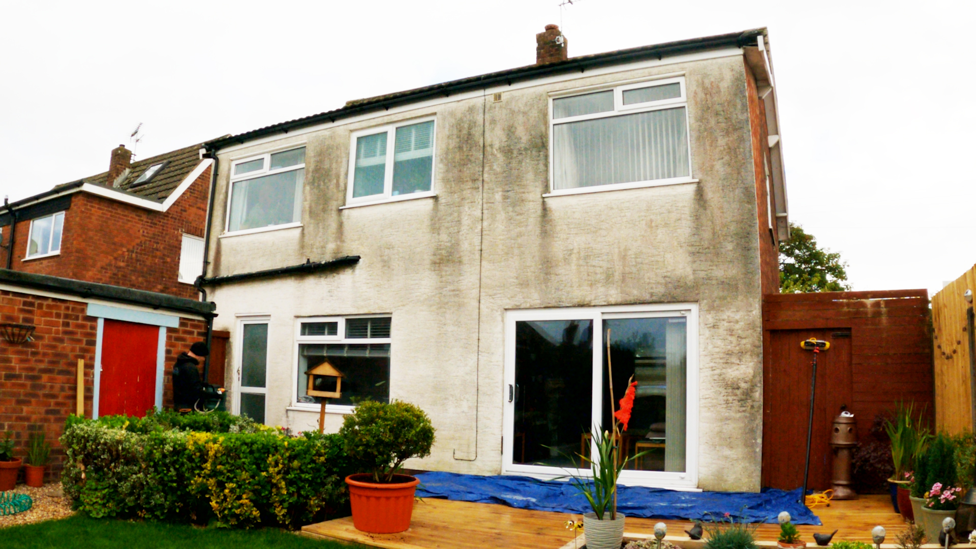 Rendered semi-detached house heavily stained green and grey before soft washing